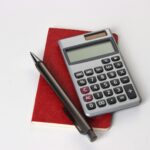 black and silver calculator beside black pen